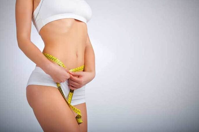 The thin girl measures the waist volume